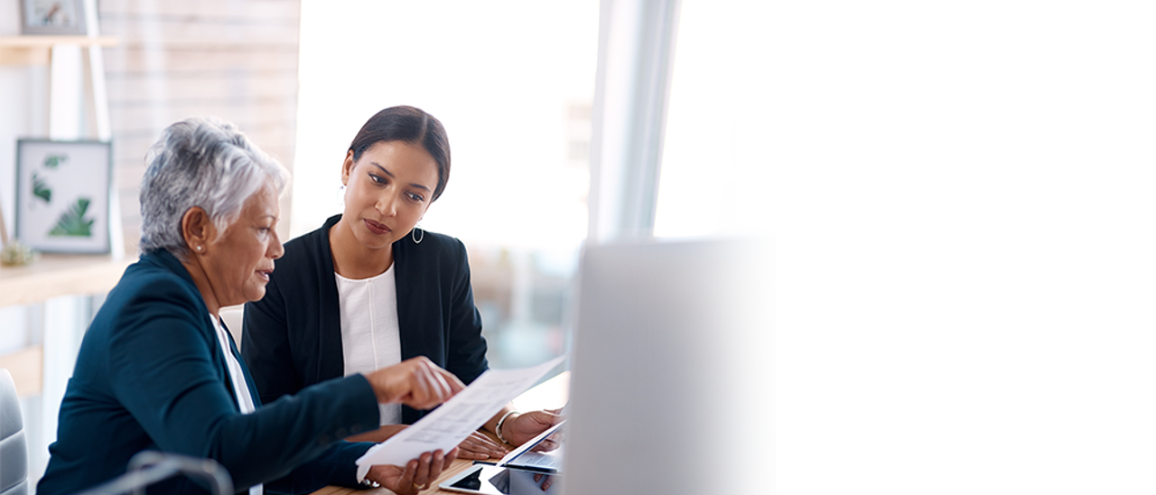 The image features a man and a woman walking together, with the man holding a young boy on his shoulders. They are all smiling and enjoying their time. The woman is wearing an orange shirt, and the man is wearing a brown shirt. They are surrounded by trees, which adds to the pleasant atmosphere of the scene.